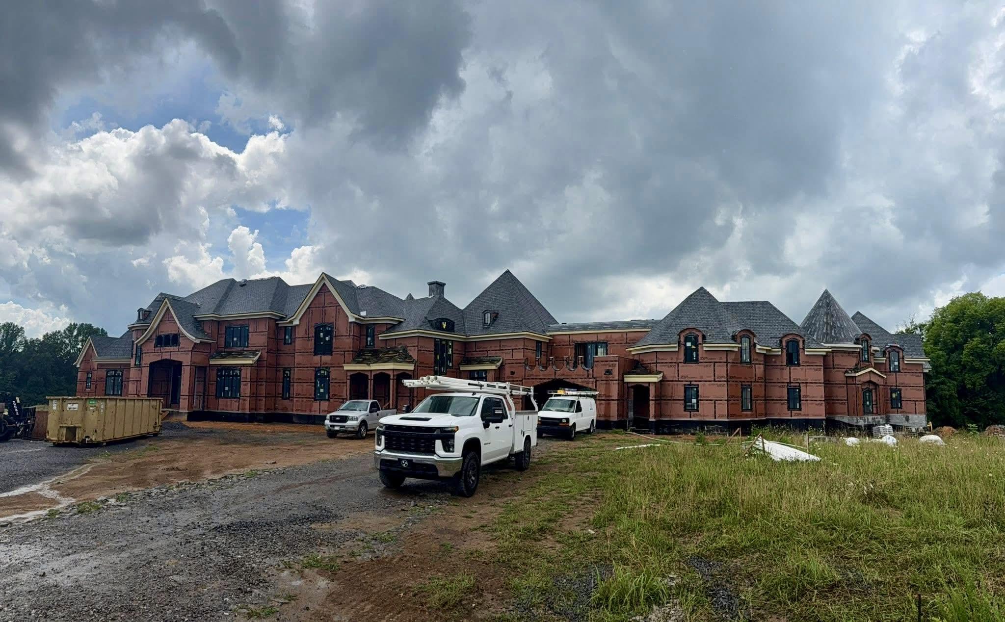 Legacy Plumbing Group trucks at a custom home rough-in project