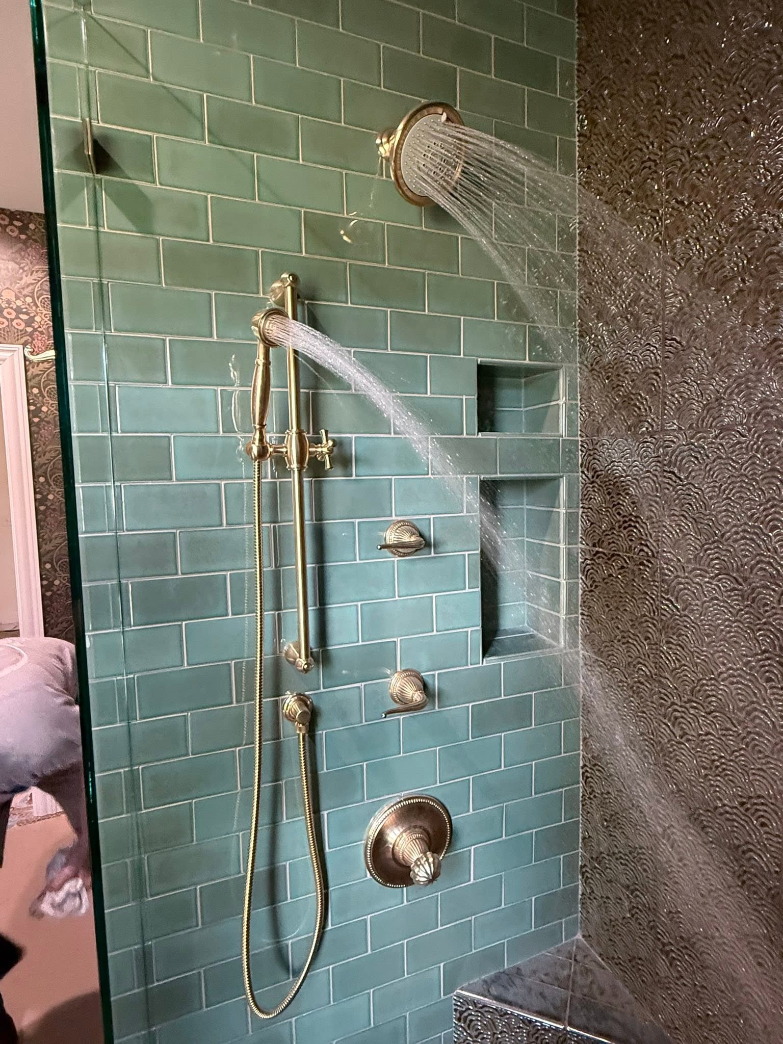 Custom tiled shower with brass shower fixtures running water