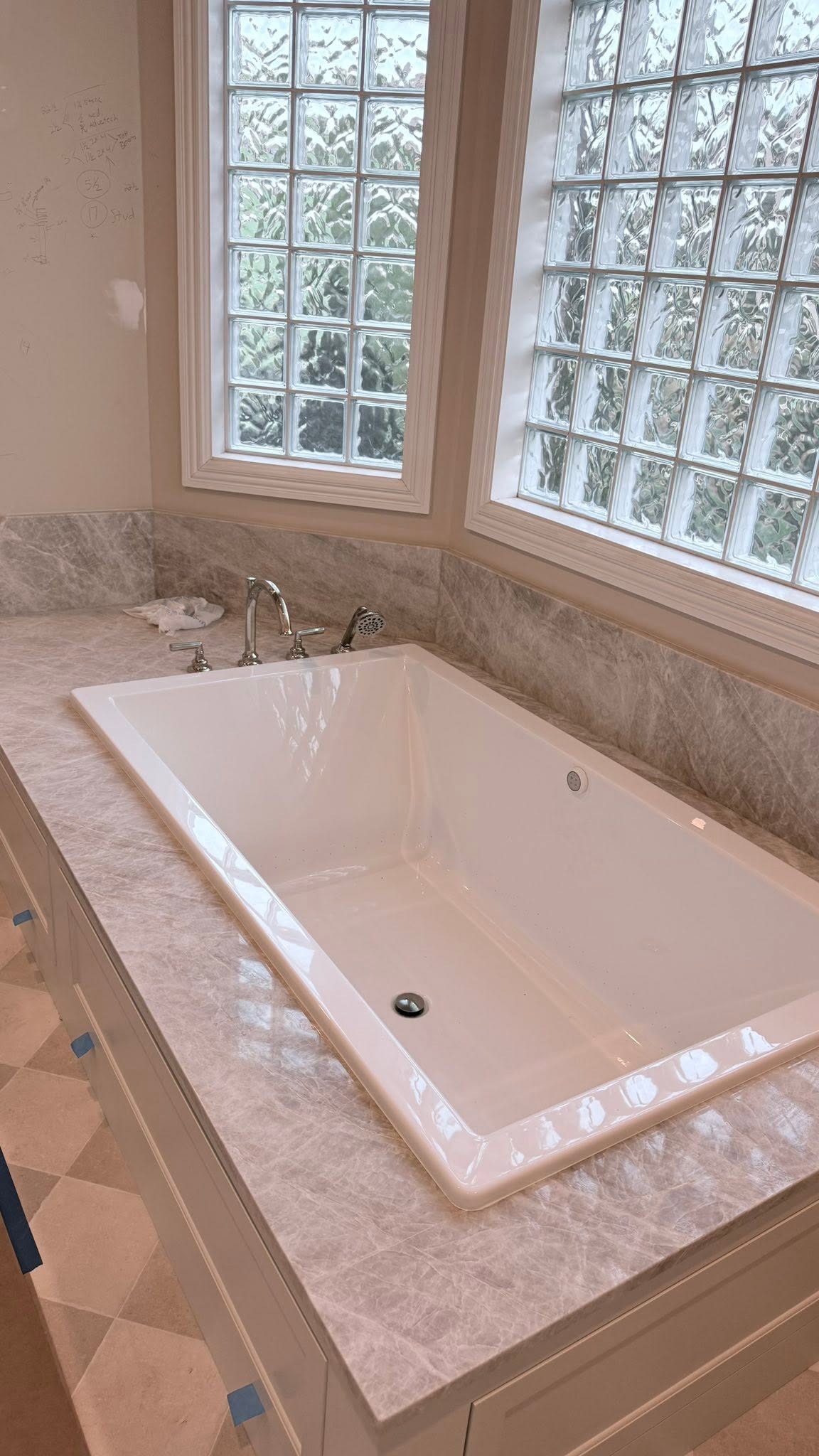 Drop-in bathtub installed below glass block windows