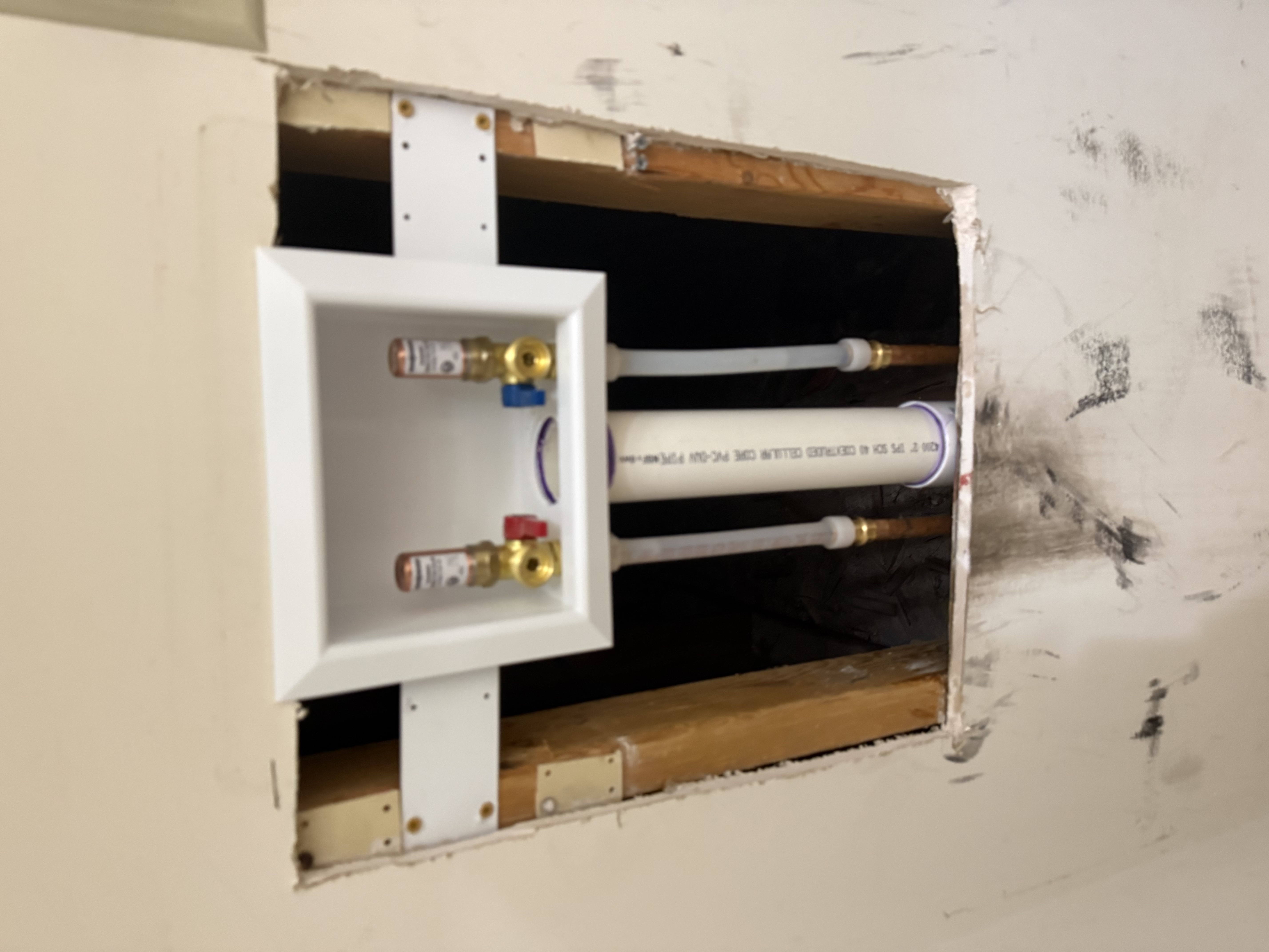 Laundry plumbing box installed in open wall
