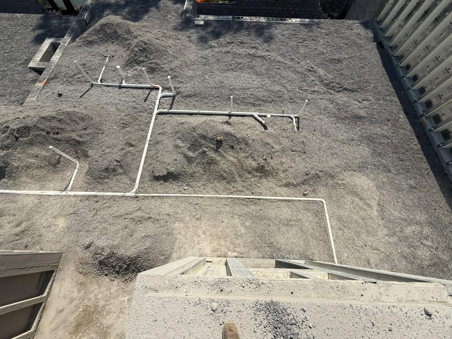 White drain and vent rough plumbing laid out before concrete