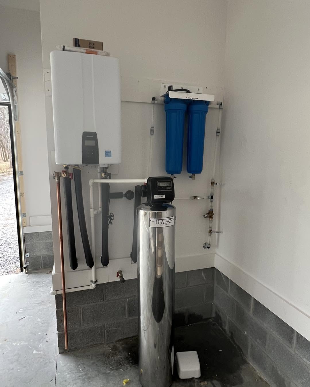 Installed whole-home water treatment system with blue filter housings